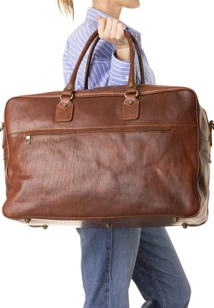 Sac de voyage en cuir marron avec poignées doubles, une pochette zippée à l'avant et des accessoires en métal doré. Présente une texture visible et un surpiquage accentué.