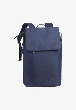 Navy blue fabric backpack with a flap closure, adjustable straps, top handle, and embossed "Bench" logo on the front.