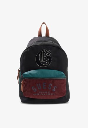 Sac à dos noir avec poignée marron, poches avant en bleu sarcelle et bordeaux, grand logo "G" au-dessus et texte "GUESS American Sports" sur la poche bordeaux.