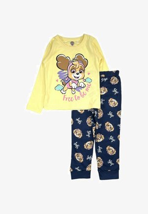 Chemise à manches longues jaune ornée d'un chien en dessin animé portant un bandeau rose et des cœurs. Pantalon navy avec un motif de chiens répétitif et le texte "Skye."
