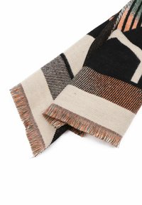 Coperta tessuta con motivi geometrici in nero, crema e arancione. Presenta bordi frangiati e un tessuto texture. Forma rettangolare.