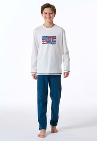 White long-sleeve shirt with a colorful "chill out" graphic, paired with blue pajama pants. Both items made from soft fabric.