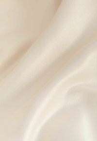 Satiinist kanga pehmeas elevandiluukes, millel on sile ja läikiv pind koos õrna sädelusega ja pehme langevusega.