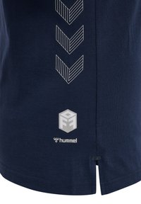 Navyblauwe t-shirt van katoen met een gestructureerd geometrisch patroon in het wit, logo gedrukt aan de onderkant en zijsplitten voor bewegingsvrijheid.