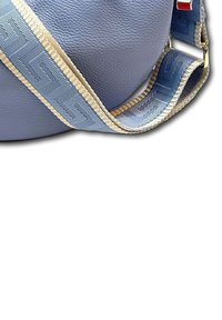 Paarse leren tas met een textuur oppervlak, voorzien van een gestreepte blauwe schouderband met beige accenten en gouden hardware.