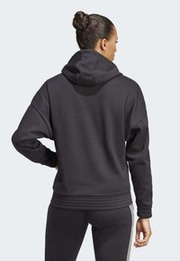 Zwarte hoodie van zachte stof, met een geribbelde zoom en manchetten, in een ontspannen pasvorm en zonder zichtbare branding.
