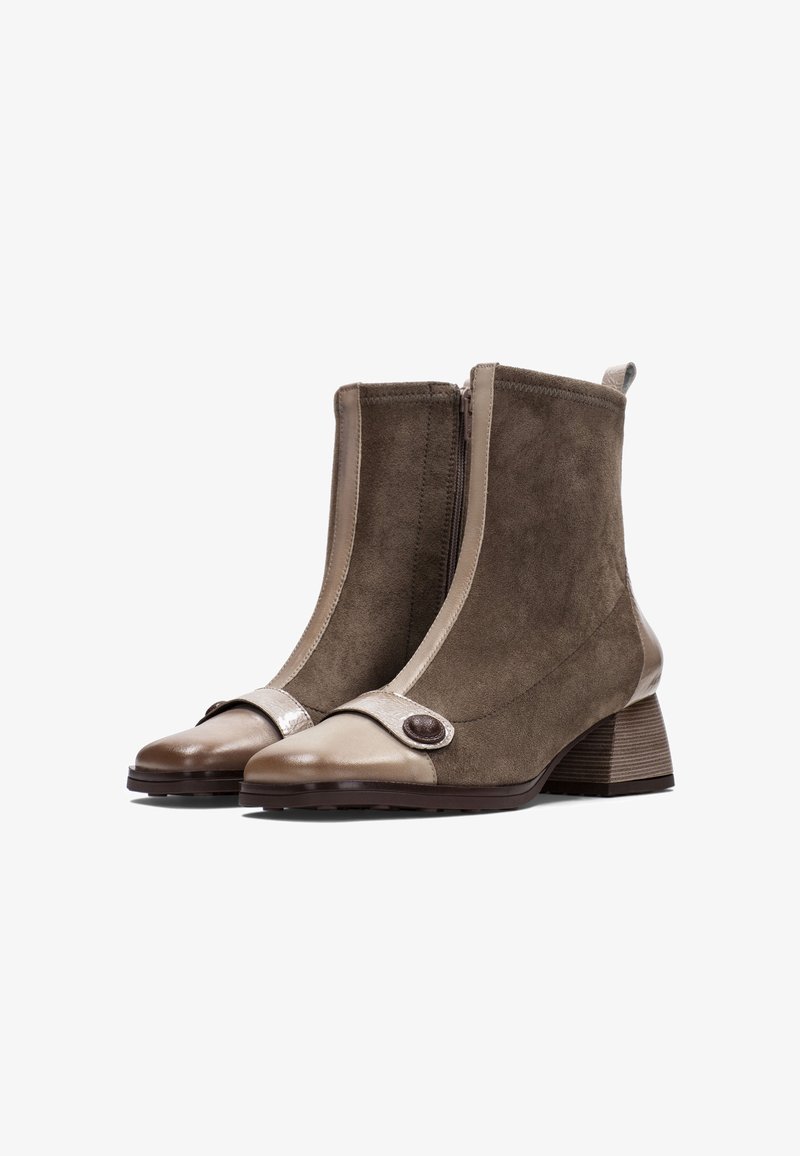 Botines de ante marrón con una puntera de cuero beige, cremallera lateral, correa decorativa, acento de botón redondo y un tacón cuadrado.