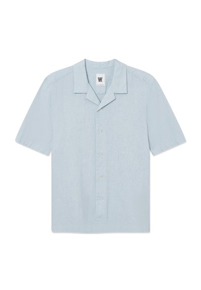 Chemise à manches courtes bleu clair en tissu texturé. Présente un col à entaille, une fermeture par bouton, et un petit logo brodé sur la poitrine.