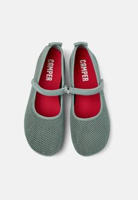 Zapatos Mary Jane de malla verde claro con una correa que tiene un acento plateado, plantilla roja y diseño de punta redonda. Nombre de la marca "Camper" visible.