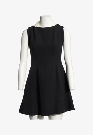 Robe noire sans manches en ligne A avec un col rond haut, présentée sur un mannequin blanc sur fond blanc.
