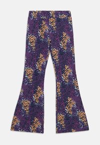 Leggings évasés avec un fond violet vif et un imprimé animal abstrait en tons orange et noir, fabriqués en matériau extensible.