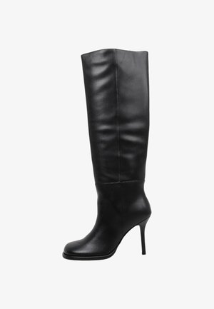 Bota negra de cuero hasta la rodilla con punta afilada y tacón de aguja.