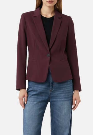 Blazer bourgogne avec une fermeture à un bouton, des revers creux et deux poches avant, associé à un jean large bleu clair.