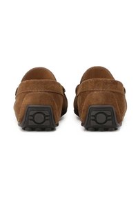 Smeđi suede mokasini s zaobljenim vrhom i niskom petom. Tekstuirana gornja površina s detaljima šivanja i gumeni potplat s uzorcima za prianjanje.