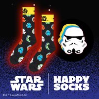 Chaussettes noires avec des personnages multicolores de Star Wars, y compris des stormtroopers, et une bande supérieure jaune. Tissu doux, design ludique.
