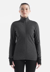 Giacca tecnica zip-up grigio scuro con maniche lunghe, tasche laterali e fori per il pollice. Presenta una texture a coste lungo le maniche.