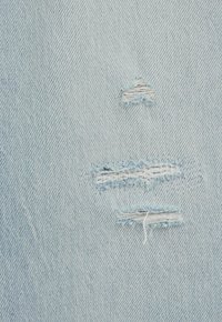 Helesinine teksariidest kangas, millel on kaks kulunud ala koos narmendavate servadega. Tekstuur on sile ja kergelt teraline, mis on tüüpiline teksariietele.