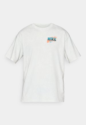 White cotton t-shirt featuring short sleeves, a round neckline, and a multicolored "NIKE" logo on the chest.