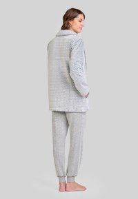 Conjunto de loungewear de rayas grises que incluye una chaqueta larga texturizada con cuello y pantalones ajustados a juego con puños acanalados.
