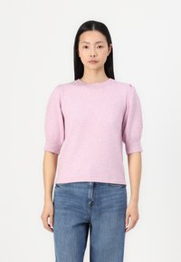 Light pink knitted sweater with short puffed sleeves, round neckline, and ribbed accents. Paired with blue denim jeans.