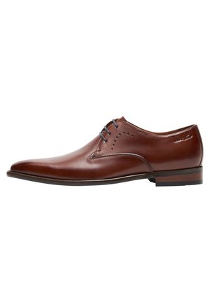 Chaussure habillée pour homme en cuir marron avec bout pointu, talon bas, laçage à l'avant et détails décoratifs perforés près des lacets.