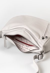 Lichtgrijze leren tas met een ritsopening, rode binnenvoering en een subtiel geometrisch patroon. Voorzien van een schouderriem en een klein label.