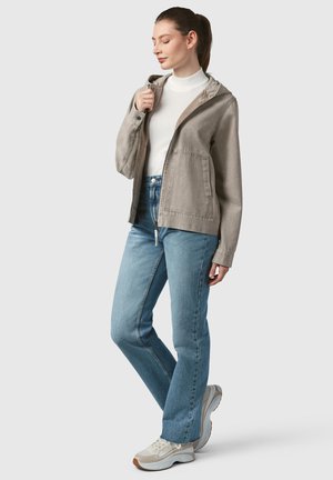 Light gray hooded jacket with a textured finish, paired with blue straight-leg jeans and beige sneakers, suitable for casual wear.