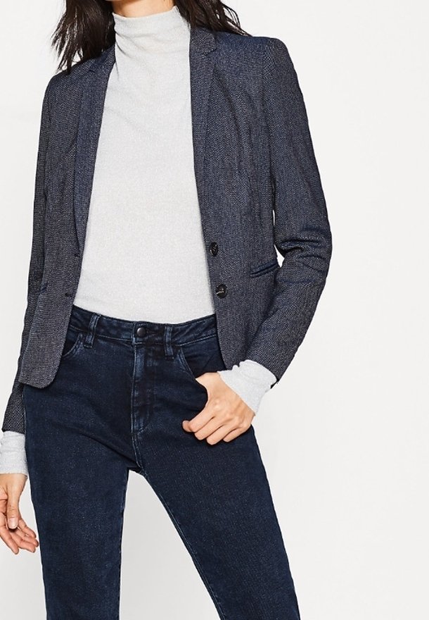 Námořnický blazer s texturovanou tkaninou, se zapínáním na jeden knoflík a dvěma předními kapsami, spárovaný se světle šedým rolákem a tmavými džíny.