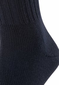 Calcetín de punto azul oscuro con la parte superior acanalada, textura suave y un diseño cónico hacia la punta. Detalles de tamaño y marca no visibles.