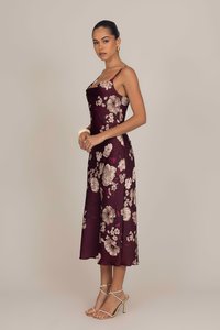 Robe florale bourgogne avec bretelles spaghetti, texture satinée, longueur genoux, ornée de grandes fleurs crème et roses sur fond sombre.