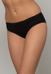 Des sous-vêtements hipster en coton noir présentent un délicat galon en dentelle et un motif floral à l'avant, offrant une texture lisse et une coupe classique.