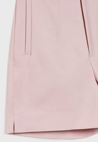 Pantalones cortos de color rosa claro, confeccionados con una tela suave, presentan pliegues laterales, un dobladillo limpio y detalles de costura sutiles.