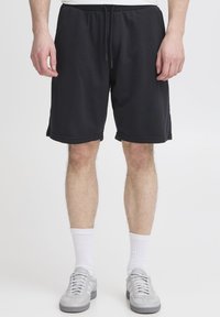 Mustad jerseyst püksid, millel on elastne vöökoht ja nöör. Omavad kahte küljetaskut ning on lõdva istuvusega, ulatudes üles põlve.