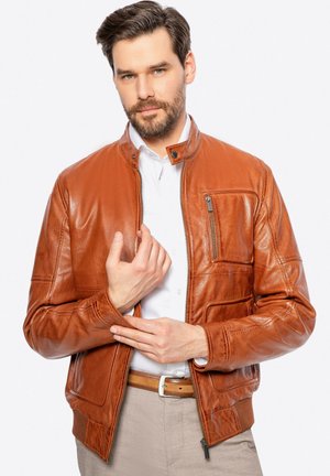 Giacca in pelle marrone con chiusura a zip, colletto rialzato e tasche frontali. Trama liscia e design aderente.