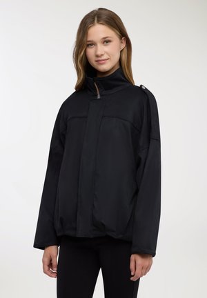 Giacca nera leggera con collo alto, zip frontale e due cuciture orizzontali. Presenta una vestibilità comoda e dettagli con bottoni a pressione sulla spalla.