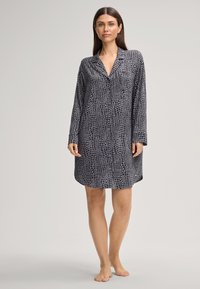 Schwarz-weiß gemustertes Langarmhemdkleid mit kragenförmigem Ausschnitt und durchgehender Knopfleiste. Weicher Stoff mit lockerer Passform.