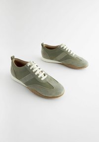 Grüne Wildleder-Sneaker mit glatter Oberfläche, cremefarbenen Schnürsenkeln, Gummisohle und diagonalen Akzentpanelen in helleren Grüntönen.