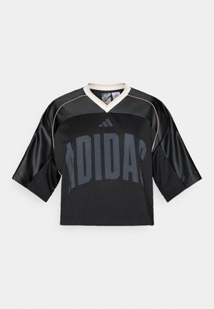 Musta lühikeste varrukatega trikoo V-kaelusega, millel on võrkmuster, beežid aktsendid ja suur sinakaslilla "ADIDAS" logo.