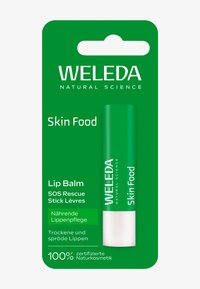 Zielone opakowanie z białym i jasnooliwkowym tekstem, prezentujące balsam do ust w sztyfcie. Etykieta głosi "Weleda Skin Food" i podkreśla naturalne składniki.
