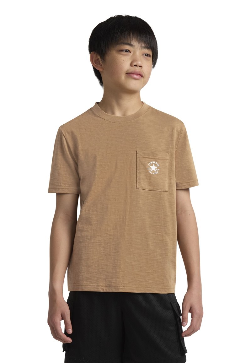 Trumpa rankovėmis marškinėliai, pagaminti iš minkštos medžiagos, su krūtinės kišenėle ir baltu apvaliu logotipu. Dėvimi su juodomis šortais.