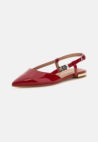 Ballerine in vernice rossa con punta affusolata, cinturino alla caviglia regolabile e dettaglio dorato sul tacco. Finitura liscia e lucida.