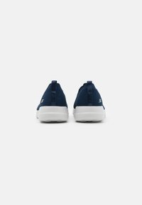 Marineblaue Mesh-Sportschuhe mit weißen Sohlen, die über ein schnürsenkelloses Design und Ziehschlaufen an der Ferse für einfaches Anziehen verfügen.
