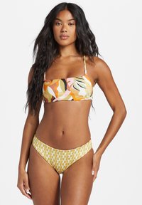 Colorful bikini featuring a patterned bandeau top with orange, pink, and green swirls and matching yellow bottoms with geometric shapes.