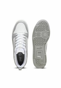 Bílé a šedé tenisky s perforovaným svrškem, plochými šňůrkami, polstrovaným límcem a vzorovanou gumovou podrážkou. Na jazyku a patě je logo.