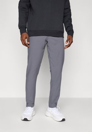 Pantalons gris ajustés en tissu doux, associés à un sweatshirt noir et des baskets blanches. Présente un design épuré avec des coutures minimales.