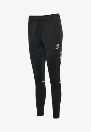 Czarne sportowe spodnie o wąskim kroju z elastycznym pasem, bocznymi kieszeniami, białym logo hummel oraz paskami w kształcie szewronów po bokach.