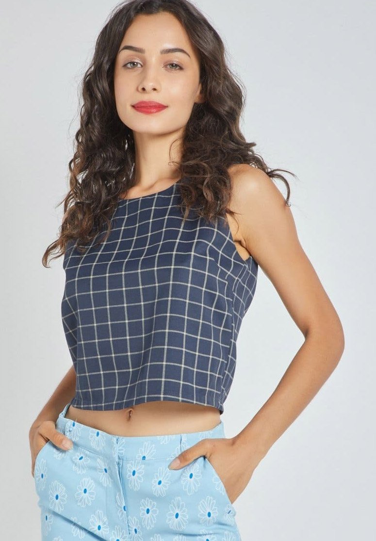 Top navy recortado con patrón de cuadrícula, diseño sin mangas, tejido texturizado, combinado con pantalones cortos azul claro con estampado de margaritas y bolsillos.