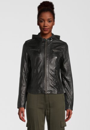 Schwarzlederjacke mit Kapuze, ausgestattet mit Reißverschlusstaschen, tailliertem Design und glatter Oberfläche. Kombiniert mit olivgrünen Cargo-Hosen.