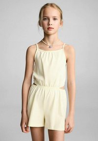 Jumpsuit giallo senza maniche con vita elastica e dettagli cut-out sui lati. Tessuto morbido e liscio con una vestibilità rilassata.