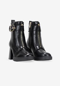 Stivali alla caviglia in pelle nera con punta arrotondata, dettagli in zip dorata, fibbia laterale e tacco spesso e texturizzato.